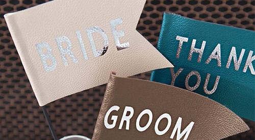 Farvet bryllupskage topper med "BRIDE", "GROOM" og "THANK YOU" skrifter, perfekt til bryllupsfejring.